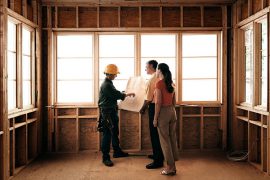 Couple qui regarde les plans de l'extension bois de leur maison avec l'architecte